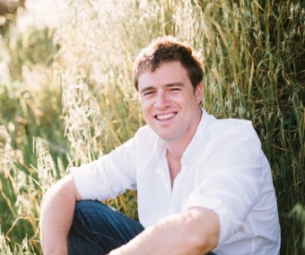 Materials alumni James Rogers, Ph.D. 2012, sitting in a field. 