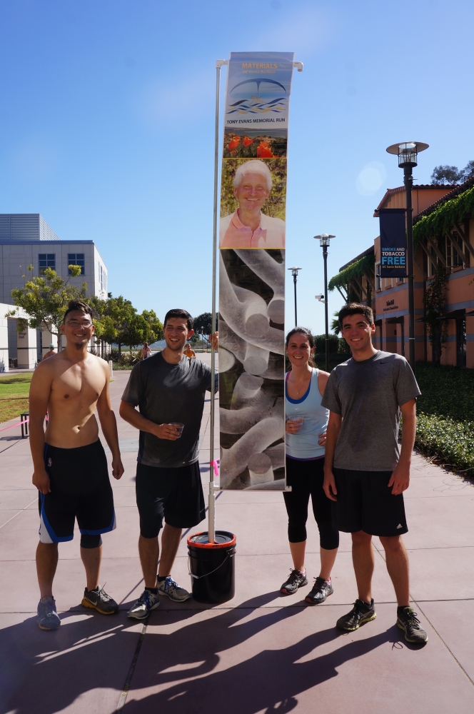 Four graduate students standing with banner of Tony Evans.